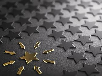 gold start among black stars on dark background